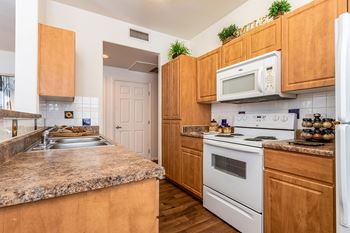 A kitchen with wooden cabinets and a granite countertop.